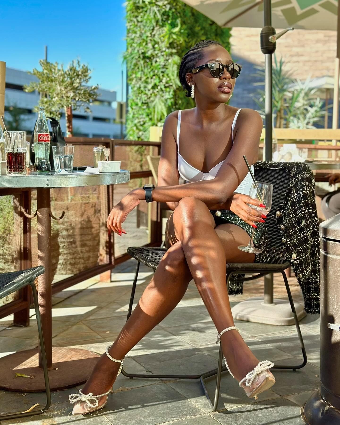 Sitting at a chic rooftop terrace café with a cocktail